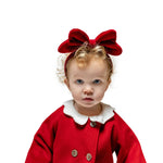 Toddler girl wearing red velvet bow headband and matching coat