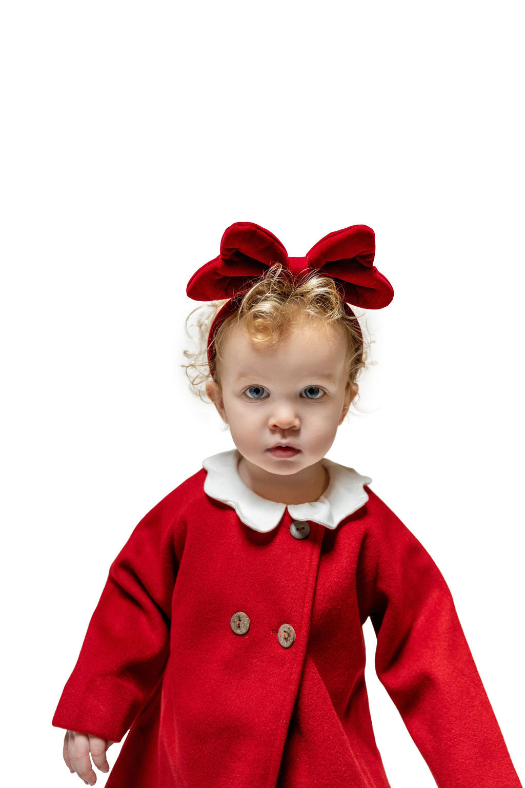 Toddler girl wearing red velvet bow headband and matching coat