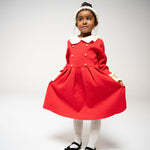 Young girl in red dress wearing the beaded pearl headband, full-body pose