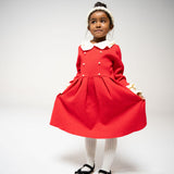 Young girl in red dress wearing the beaded pearl headband, full-body pose