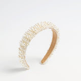 Beaded pearl headband with layered pearl detailing on a neutral background