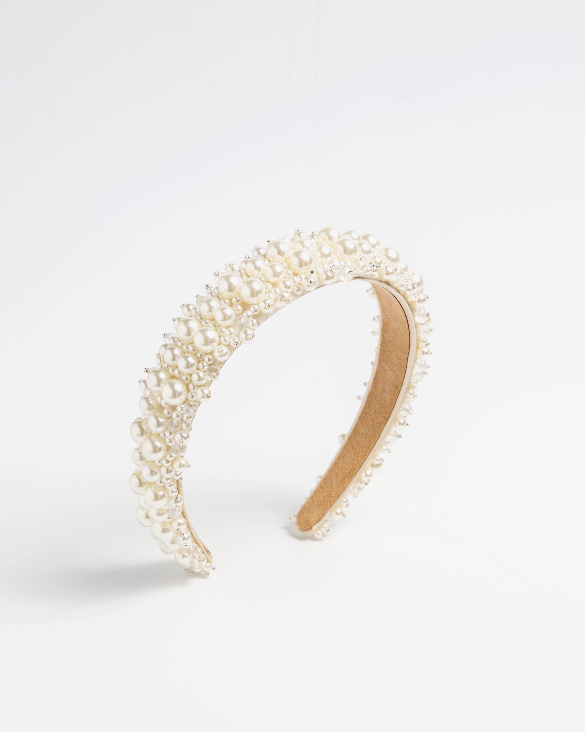 Beaded pearl headband with layered pearl detailing on a neutral background