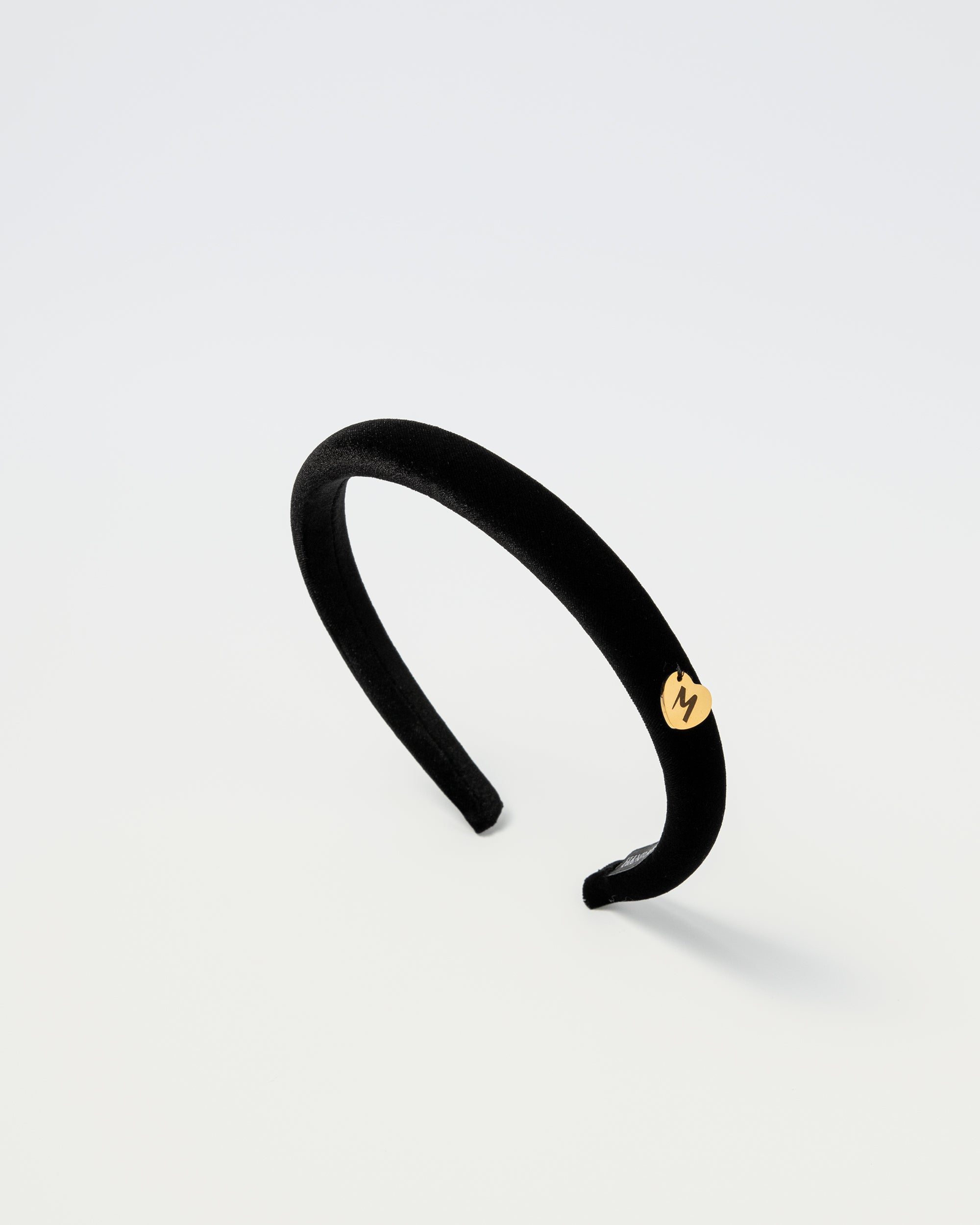 Black velvet kids headband with gold Maudysh logo charm on the side
