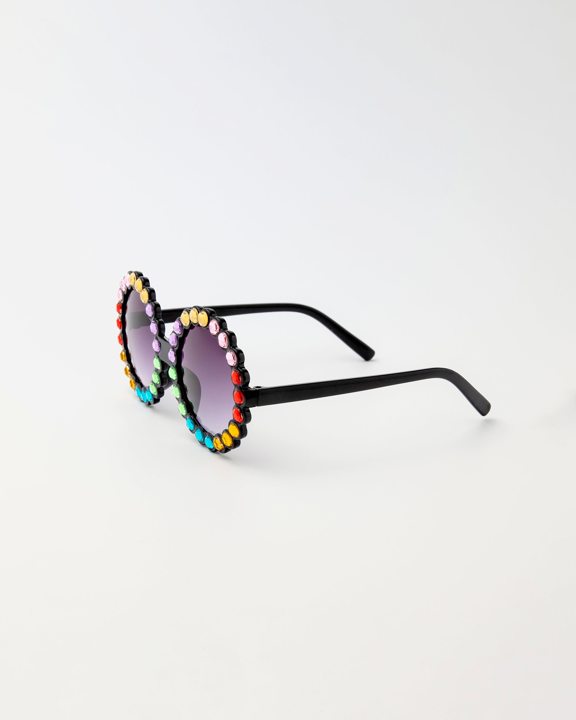 Carrousel Color sunglasses in side angle showing black arms and rainbow rhinestones on round frames