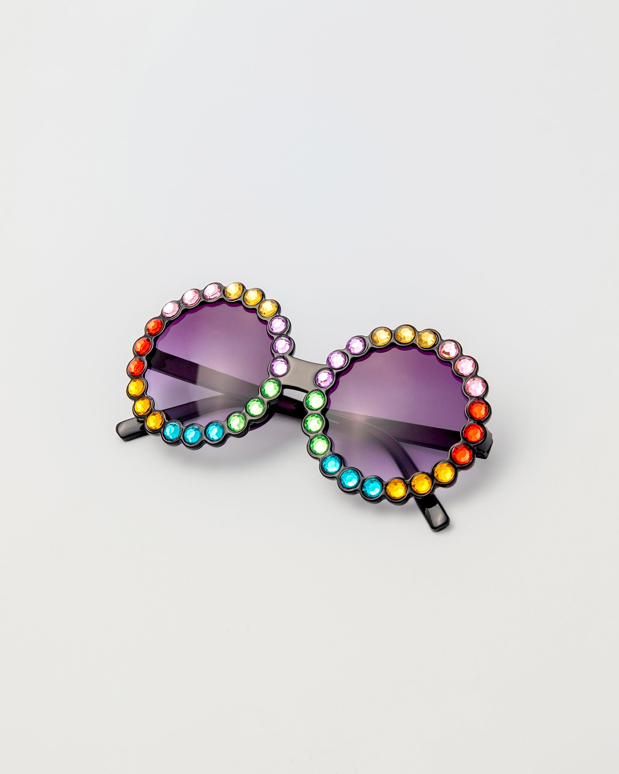 Carousel Color sunglasses with round black frames and rainbow rhinestone trim, shown from front on white background
