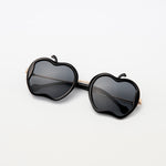 Gala Princess sunglasses in black with gold arms and apple silhouette, laid flat on white surface