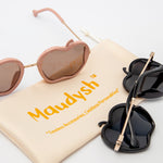 Gala Princess sunglasses in pink and black shown with Maudysh drawstring pouch on white background