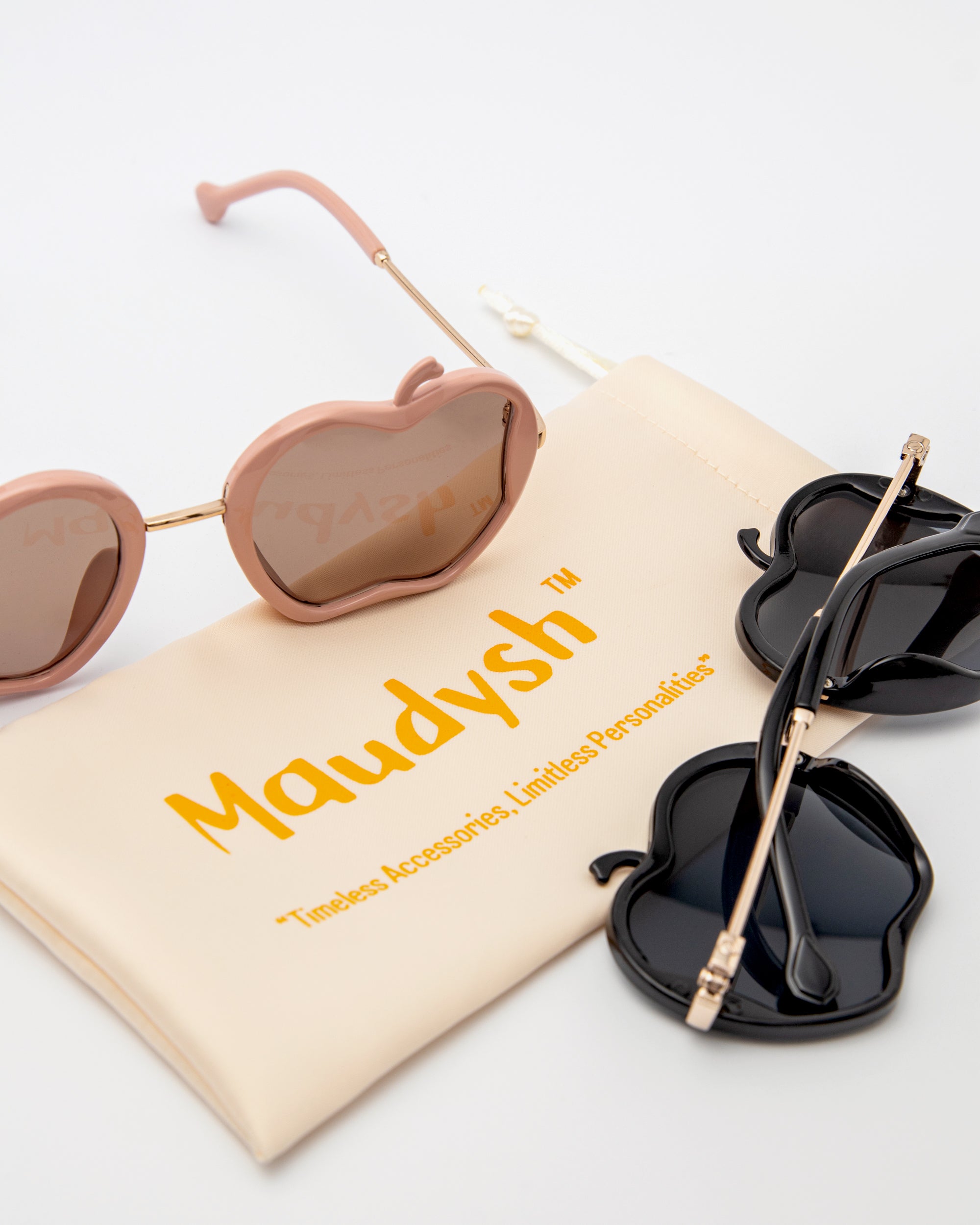 Gala Princess sunglasses in pink and black shown with Maudysh drawstring pouch on white background
