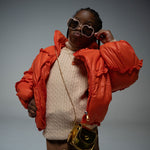 Girl posing in puffer jacket wearing Gala Princess sunglasses in pink with apple-shaped frames