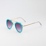Jet Set sunglasses with turquoise and gold aviator-style frames and cool purple tinted lenses on white background
