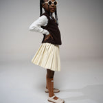 Girl in side profile pose wearing Little Miss Beary Glasses, styled with cream pleated skirt and brown vest