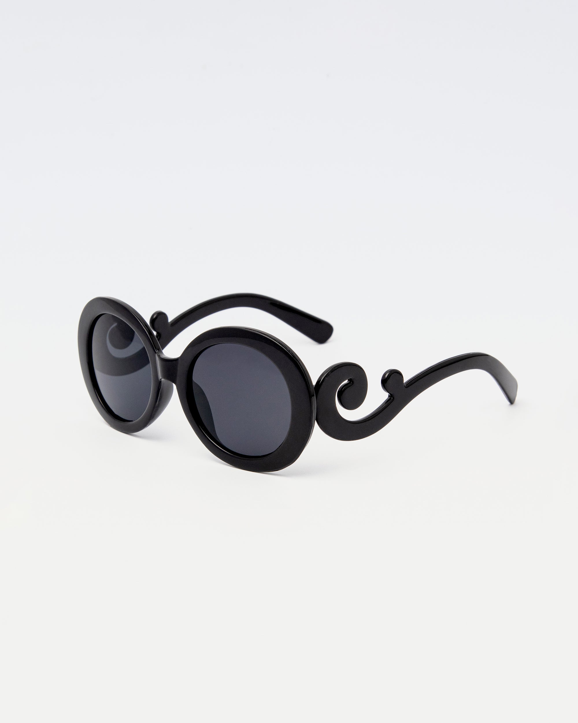 Noirette Sunglasses with black oval frames and statement curved arms, displayed against white background