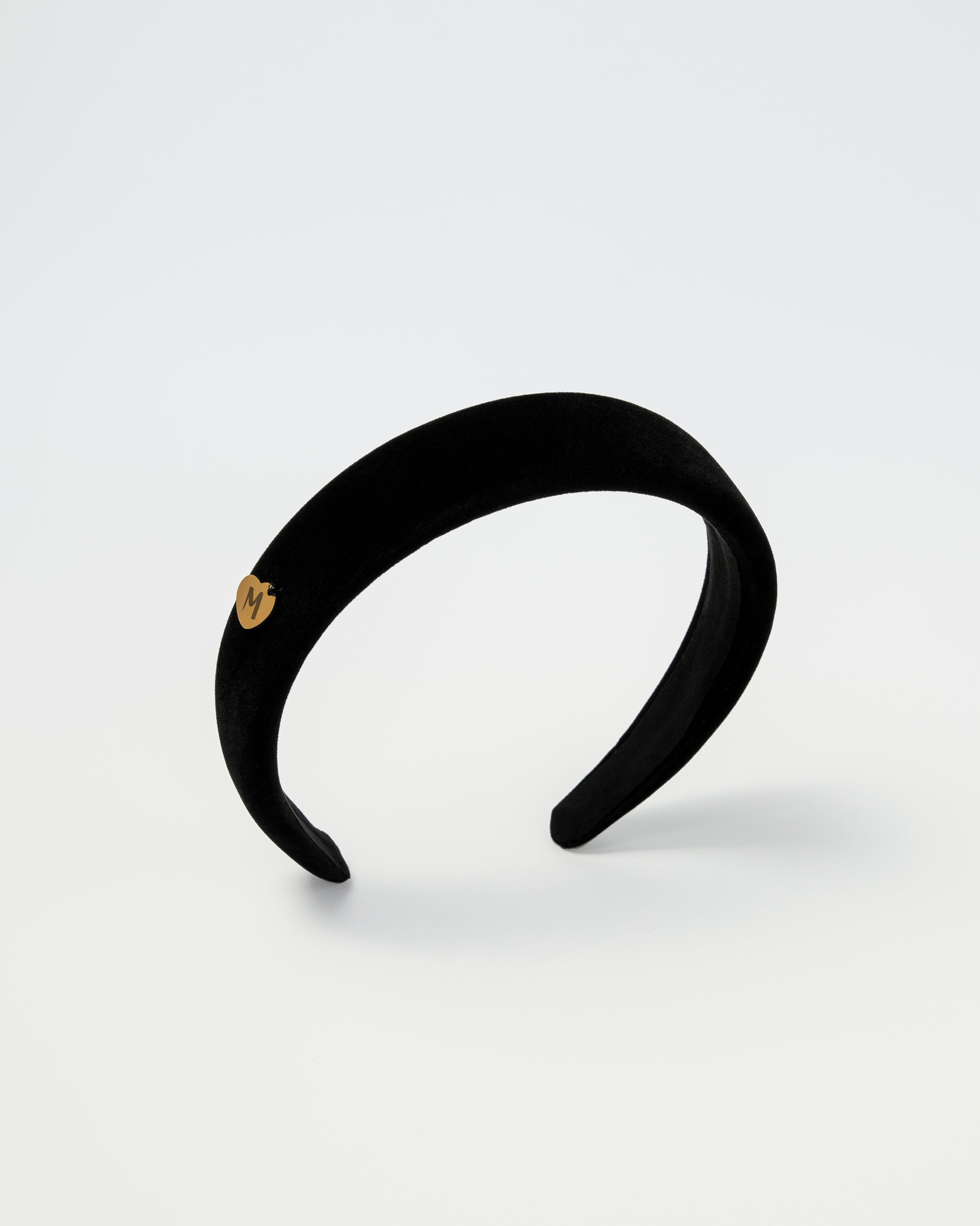 Padded black velvet headband for kids with a gold Maudysh logo charm on the side