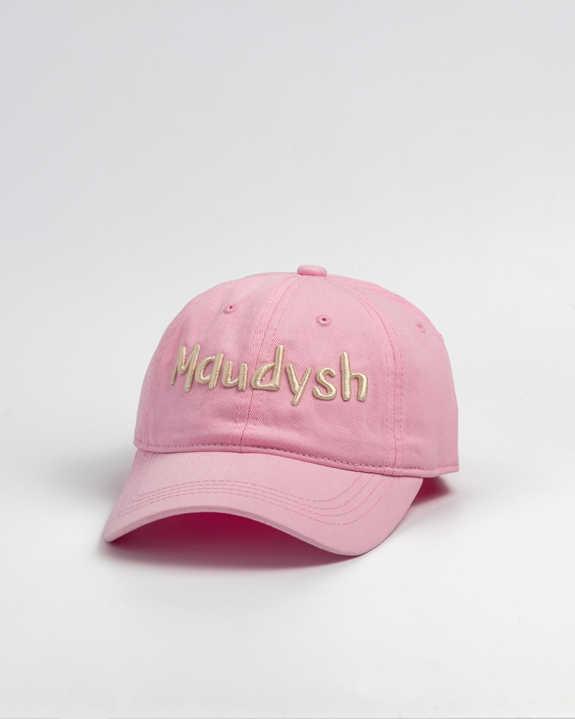 A bubblegum pink baseball cap with the word Maudysh embroidered on the front