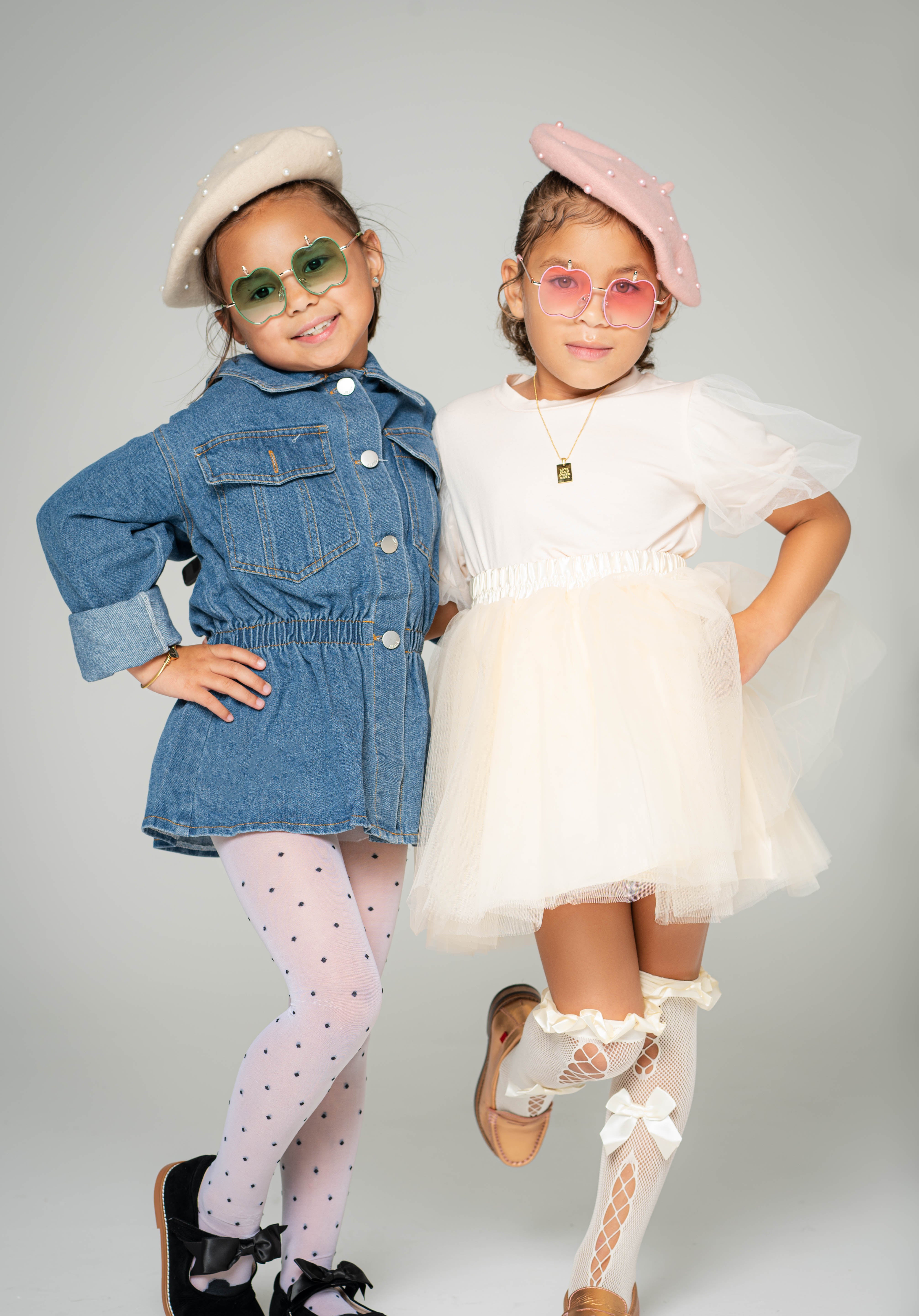 Two girls wearing Apple Delight sunglasses in pink and green with pearl berets and fashion outfits
