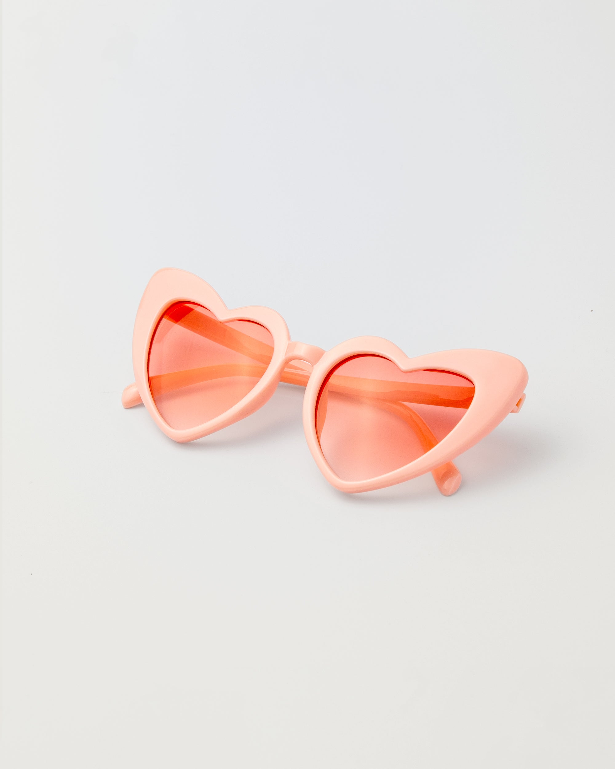 Pink heart-shaped kids sunglasses with playful princess design