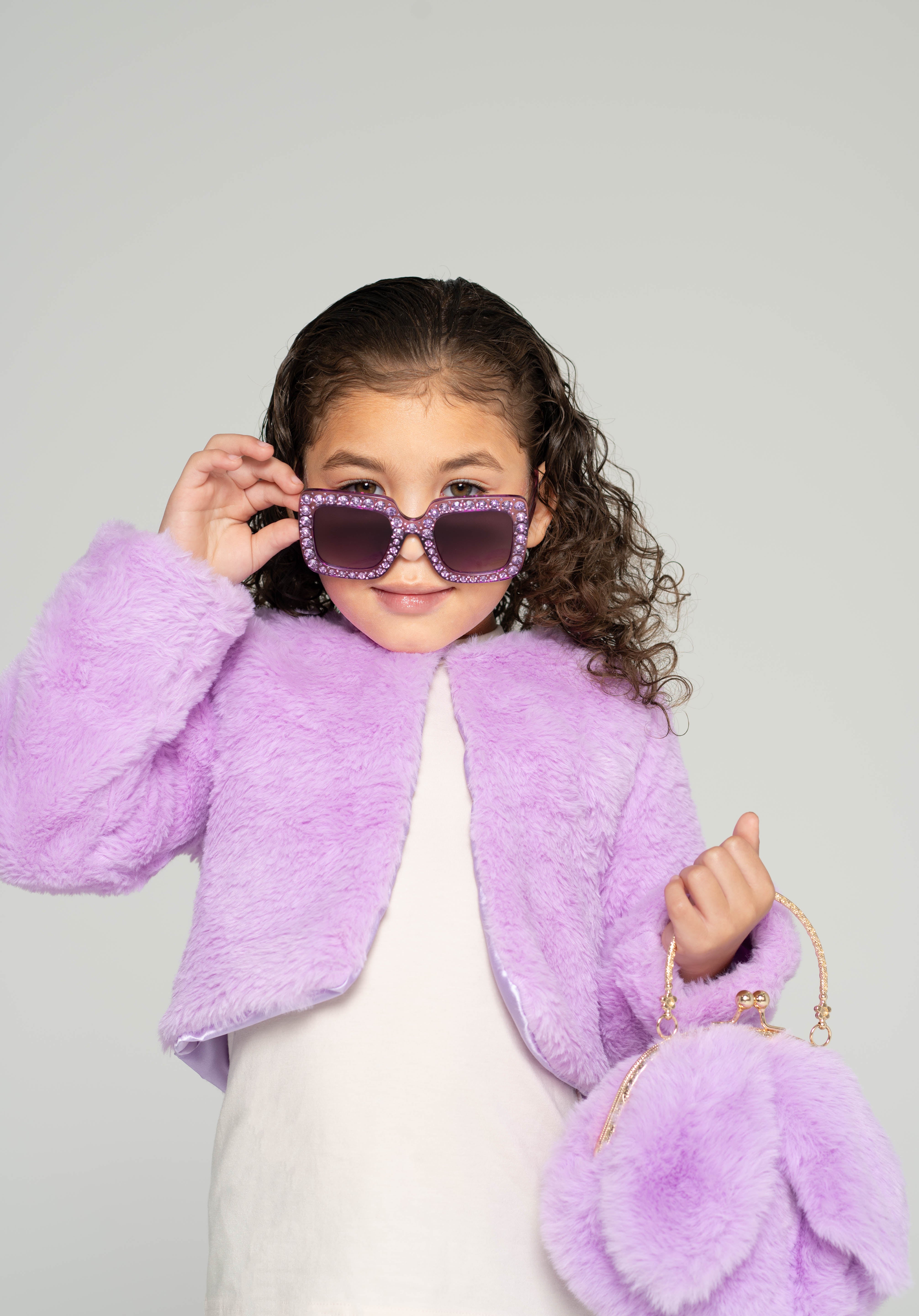 Girl wearing Sparkle Lilac Blooms sunglasses and holding a fluffy lilac bunny purse