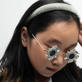 Girl wearing jeweled Starstruck Symmetry Sunglasses with silver headband