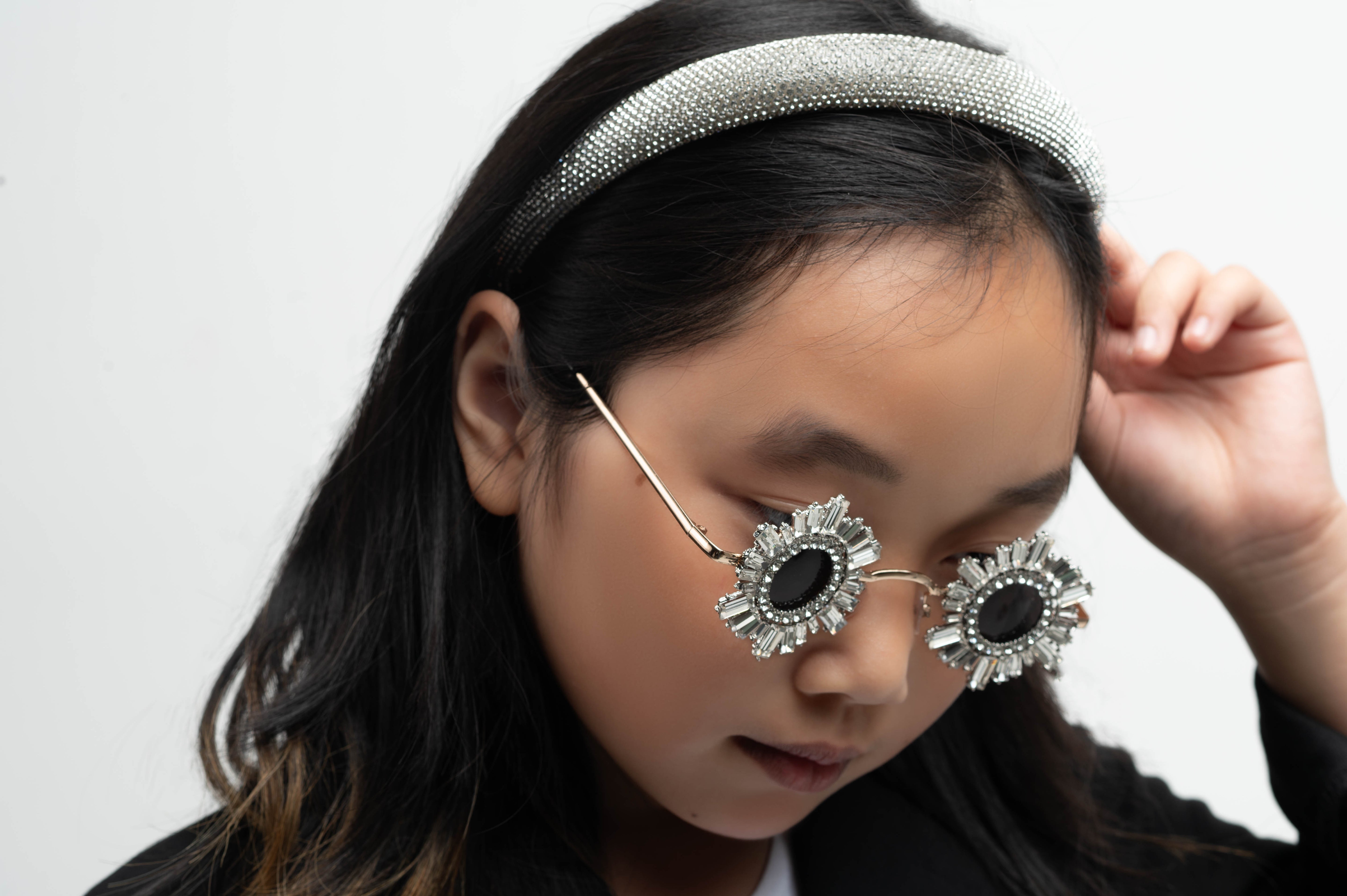 Girl wearing jeweled Starstruck Symmetry Sunglasses with silver headband
