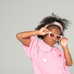 Close-up of child wearing pink sweetheart princess sunglasses