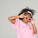 Close-up of child wearing pink sweetheart princess sunglasses