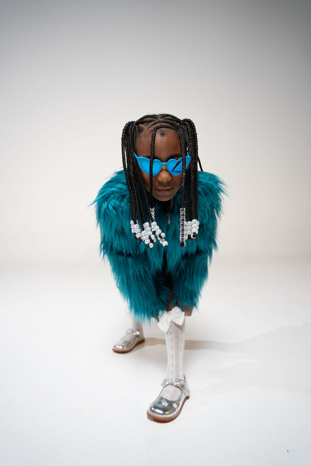 Side profile of child in blue striped shirt and heart sunglasses